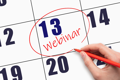 13th day of the month. Hand writing text WEBINAR and circling the calendar date. Webinar date on calendar or agenda. Day of the year concept.