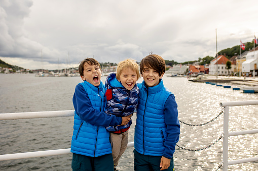 Child, visiting little town in south Norway, Arendal, on a rainy summer day, enjoying splendid views