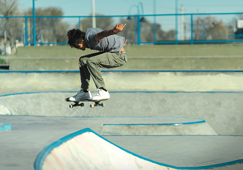 Skateboarder suspended in the air above the concrete of skatepark. Copy Space