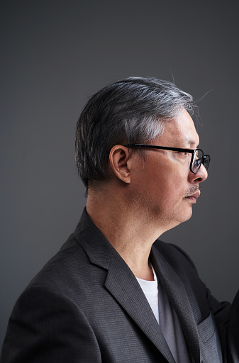 Profile portrait of serious mature businessman in grey suit
