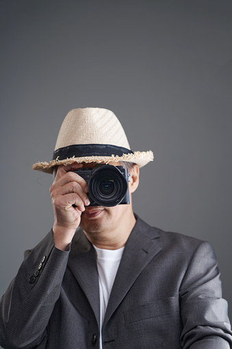 professional photographer with wear hat holding camera