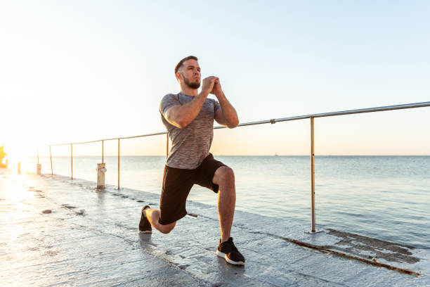 istock Athletic man practicing lunges in the early morning on the beach 1419356236