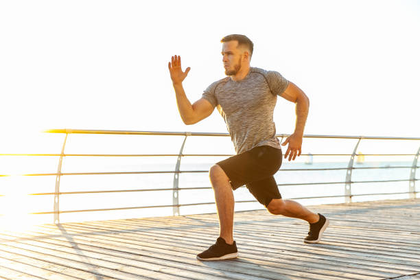 istock Young athletic man practicing warm-up before exercising on beach in the early morning. Healthy lifestyle 1419356272