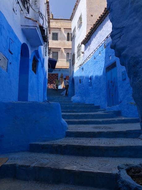 High angle shot of a narrow lane in Chefchaouen, the Blue Pearl. High angle shot of a common narrow lane painted blue in Chefchaouen mountain village, also called by the Blue Pearl or the Blue town. Morocco. moroccan currency photos stock pictures, royalty-free photos & images