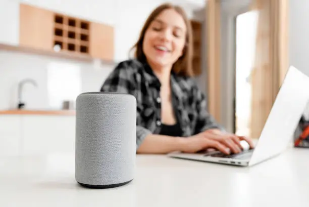 Woman using smart speaker, smart home concept