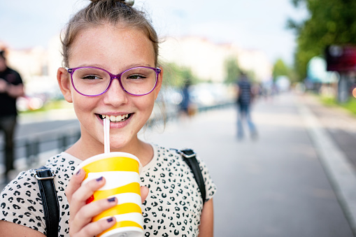 Beautiful teenage girl enjoying a smoothie outdoors