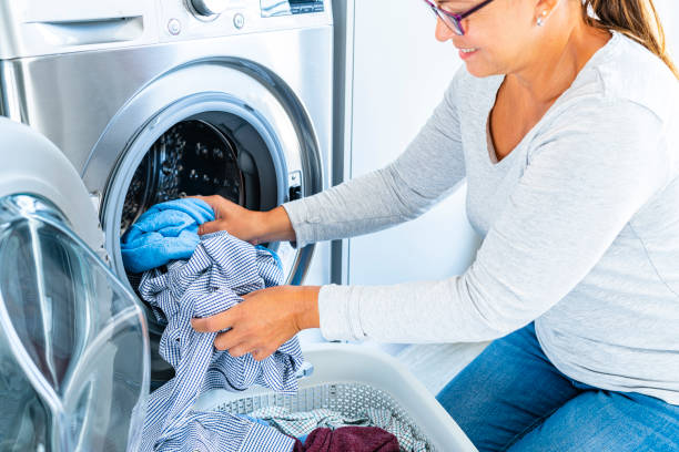 istock Woman loading the washing machine at home 1419360608