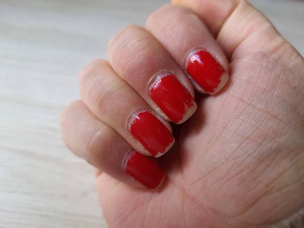 Peeled red nail polish in a woman's hand. Close up. Peeled red nail polish in a woman's hand. Close up. red nail polish stock pictures, royalty-free photos & images