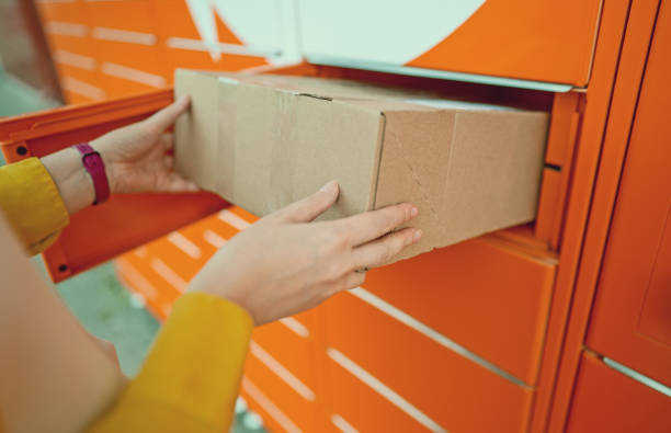 istock Woman sending mail via automated self-service post terminal machine. 1419363173