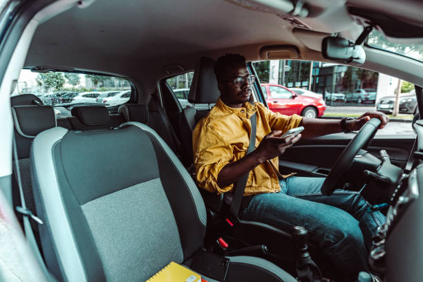 istock Happy young African-American man driving and using smart phone 1419363348