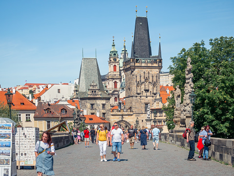 Prague, Czech Republic - June 2022: Crowds of tourist people walking and strolling on the famous Charles Bridge in Prague.
