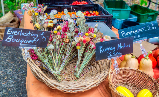 Farmer's market stand with bouquets of dried flowers and other produce