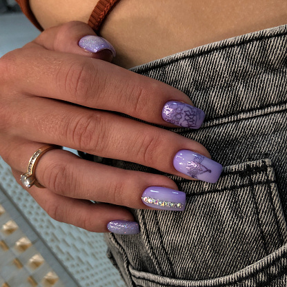 Hands of a woman with purple manicure on nails.Manicure beauty salon concept. Empty place for text or logo.