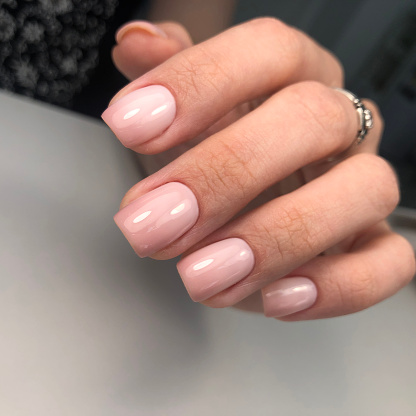 Hands of a woman with pink manicure on nails.Manicure beauty salon concept. Empty place for text or logo.