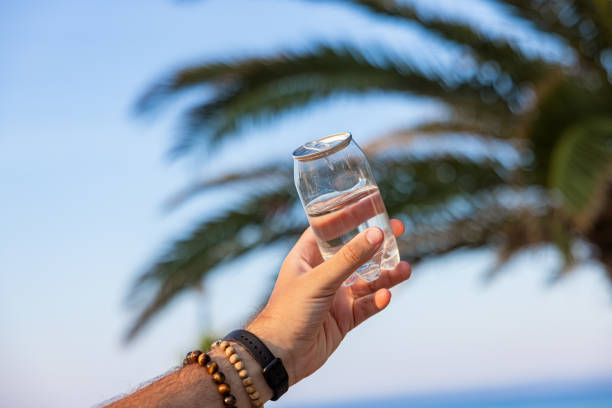 istock Unrecognizable man holding plastic can with water, with a nature as a background 1419371086