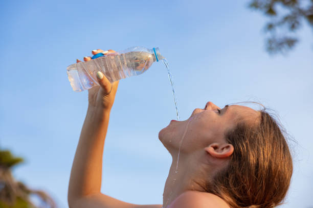 istock Woman pouring water from plastic bottle into her mouth 1419371949