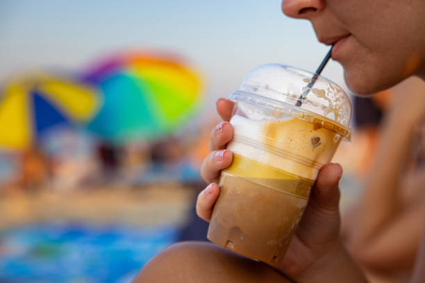 istock Unrecognizable woman drinking iced coffee from the plastic cup, at the beach 1419372061