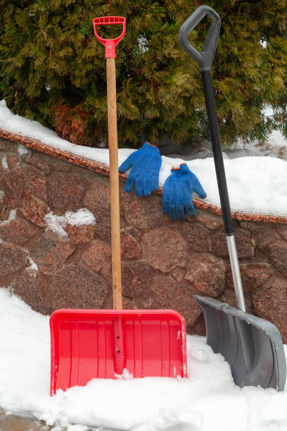 istock Two plastic snow shovels stand in front of  fence 1419373984