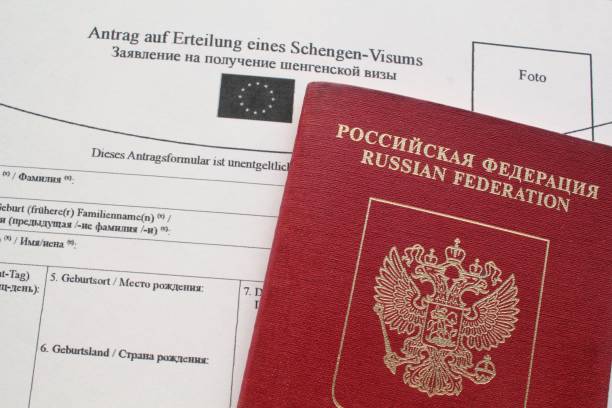 istock Passport and Schengen visa application form in Russian and Deutsch language on background 1419374324