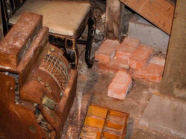 Rusty abandoned cash register amongst stored junk and bricks