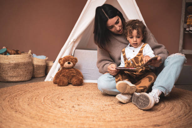잠들기 전에 침실에서 작은 아들에게 책을 읽는 어머니. 백인 엄마가 바닥에 앉아있는 이야기를 전합니다. - leopard 2 뉴스 사진 이미지