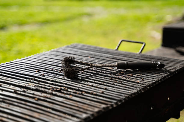 outdoor barbeque grill with black brush tool for cleaning on top stock photo