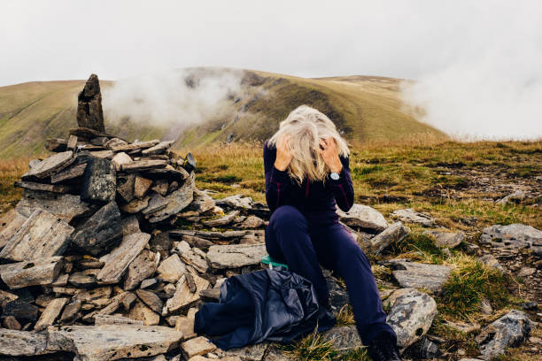 Midge fly trouble Woman shaking midge flies from her hair on the summit of a mountain called Beinn Eibhinn, in the Highlands of Scotland. It's pronounced like 'Ben', the name, and 'eon', as in a very long time period. midye stock pictures, royalty-free photos & images