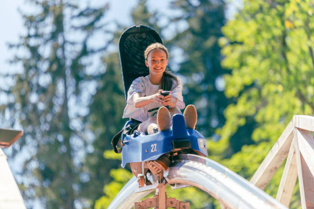 istock Dirl is going down a mountain with a roller coaster over a wooden bridge. Forest in background 1419392777