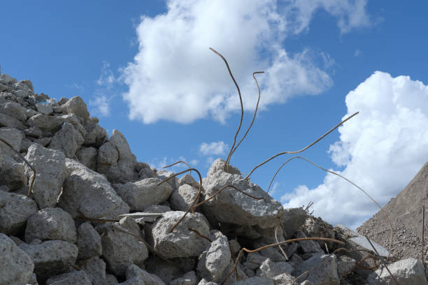 istock Mountain slopes from construction debris against a blue sky with clouds. There are many broken concrete pieces and bent rods of rusty rebar. Background. 1419393443