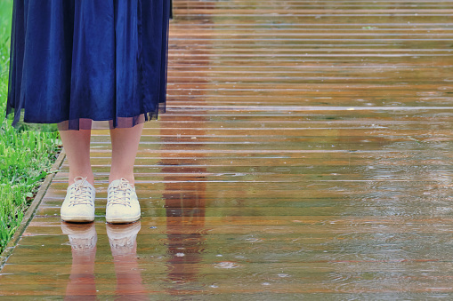 Legs of woman standing in the rain in bad autumn weather