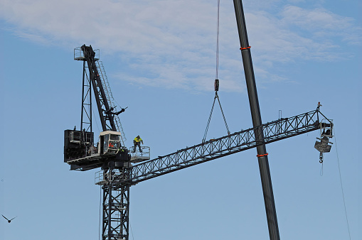 Installing and erecting a heavy duty industrial construction crane on a new high rise multistory building site. Mann St. Gosford, New South Wales, Australia.May 11, 2019.