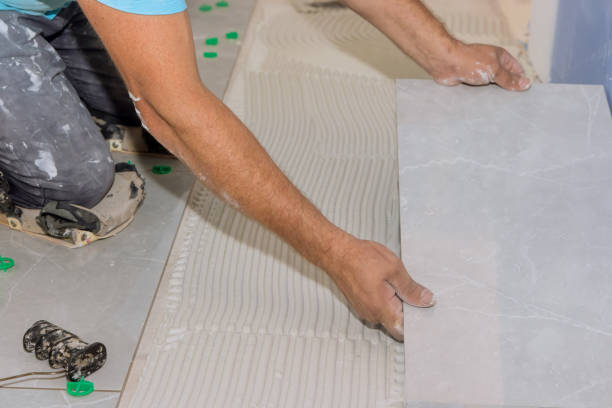 istock The placement of ceramic floor tiles on an adhesive surface with home construction workers 1419400314