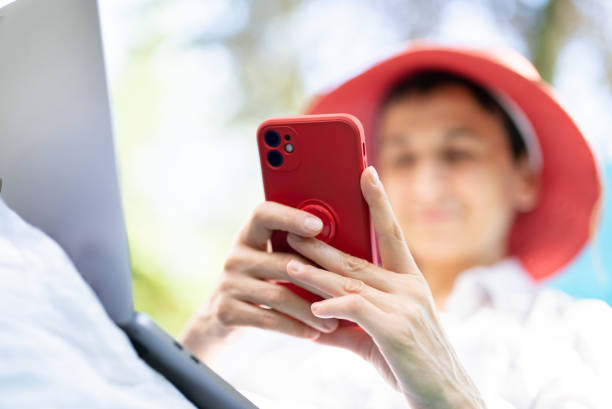 istock Woman with red hat using smartphone 1419414793