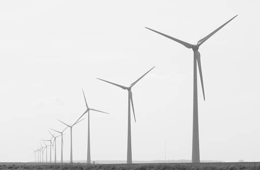 A row of wind turbines in a field in France