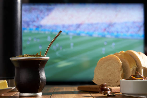 istock watching the soccer world cup on TV drinking mate 1419424212