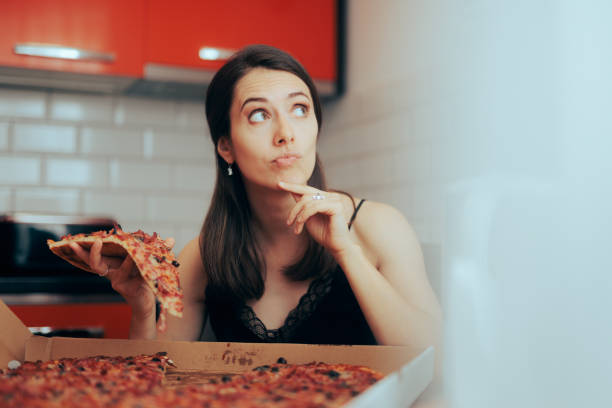 Woman Thinking about Cheating her Diet with pizza stock photo