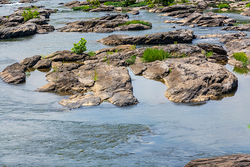 A rocky section of the Potomac River where the water is low. Calm scene.