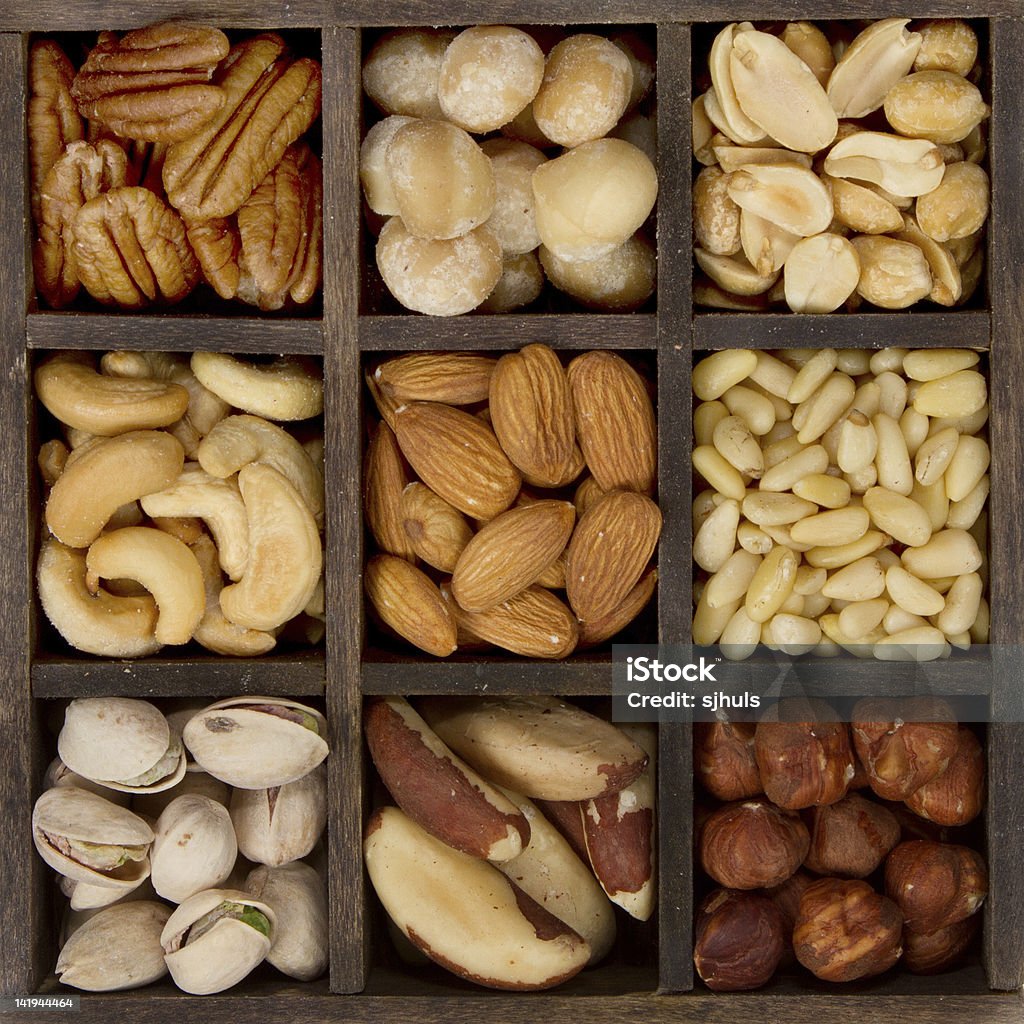 assorted nuts for a background assorted nuts nine varieties for a background in a printers box, almond, cashew, brazil, hazelnut, peanut, pecan, pine, pistachio, macadamia Almond Stock Photo