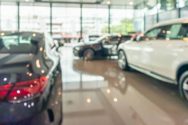 coches nuevos en el interior de la sala de exposición fondo abstracto borroso - sedan fotografías e imágenes de stock