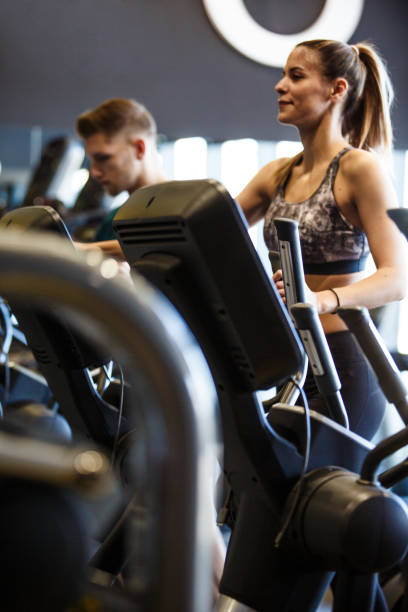 istock Fit young woman enjoying a workout on elliptical machine 1419445566