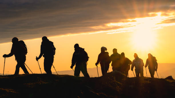 istock Group of hikers walking in mountains against setting sun 1419448298