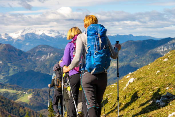 istock Female hikers in group in mountains, ascending on grassy slope 1419448312