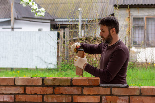 istock a man builds a wall of bricks, lays a brick on a cement-sand mortar 1419452587