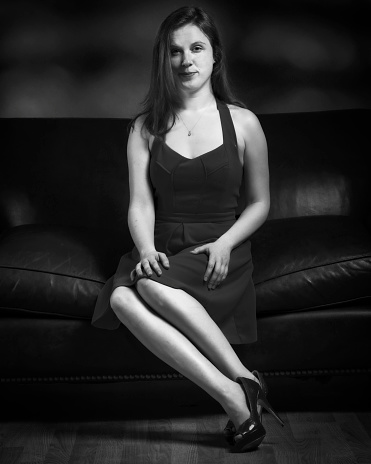 Seated young woman studio portrait in black and white.