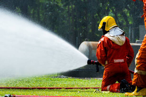 istock Fire man spray water from hose for fire fighting. Firefighter spraying a straight steam 1419454314