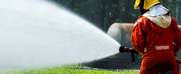 istock Fire man spray water from hose for fire fighting. Firefighter spraying a straight steam 1419454408