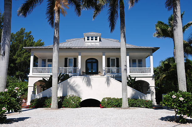 istock Two story beach house with large front porch and palm trees 141945975