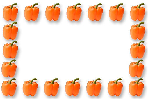 Overhead shot of orange bell pepper frame on white background.