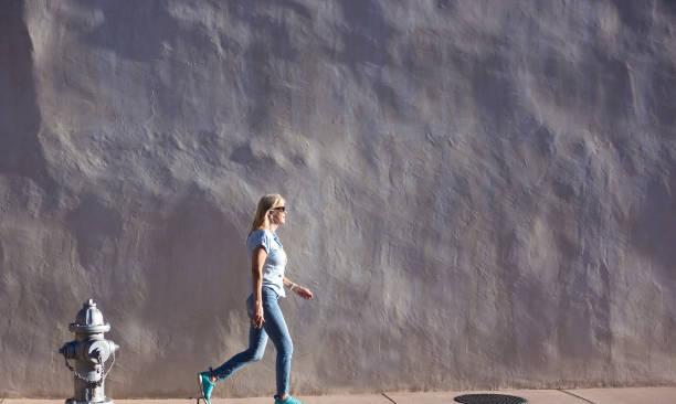 Woman Walks by Sunlit Adobe Wall, Fire Hydrant, Southwest USA