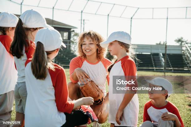 Elementary Age Children Are Athletes Playing Little League Baseball Together On Coed Sports Team With Coaches At Ballfield Stock Photo - Download Image Now